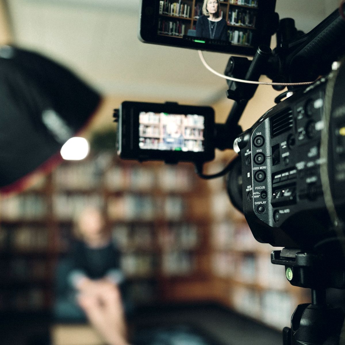 Video camera framing an attorney inside a law library