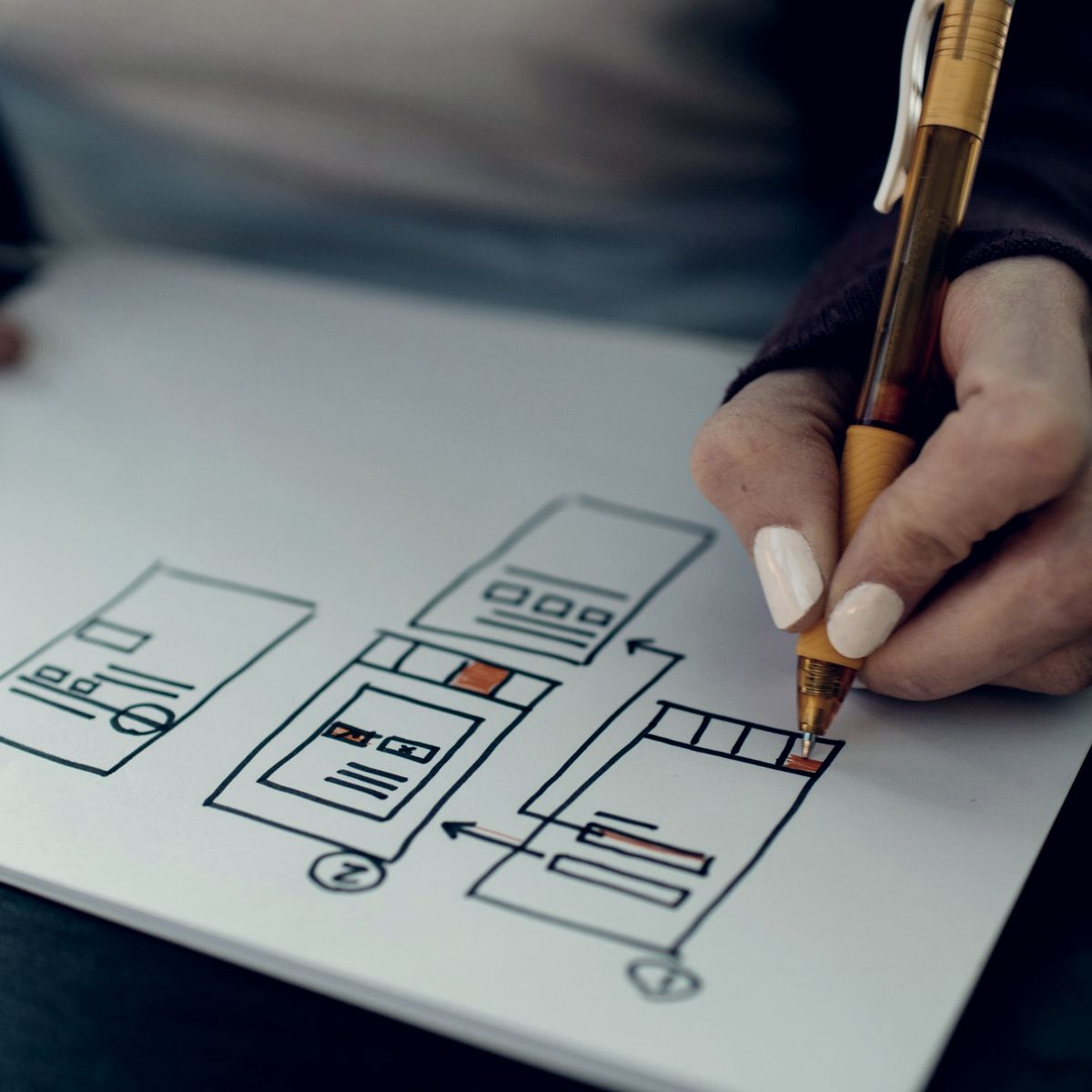 Designer sketching a firm website wireframe by hand