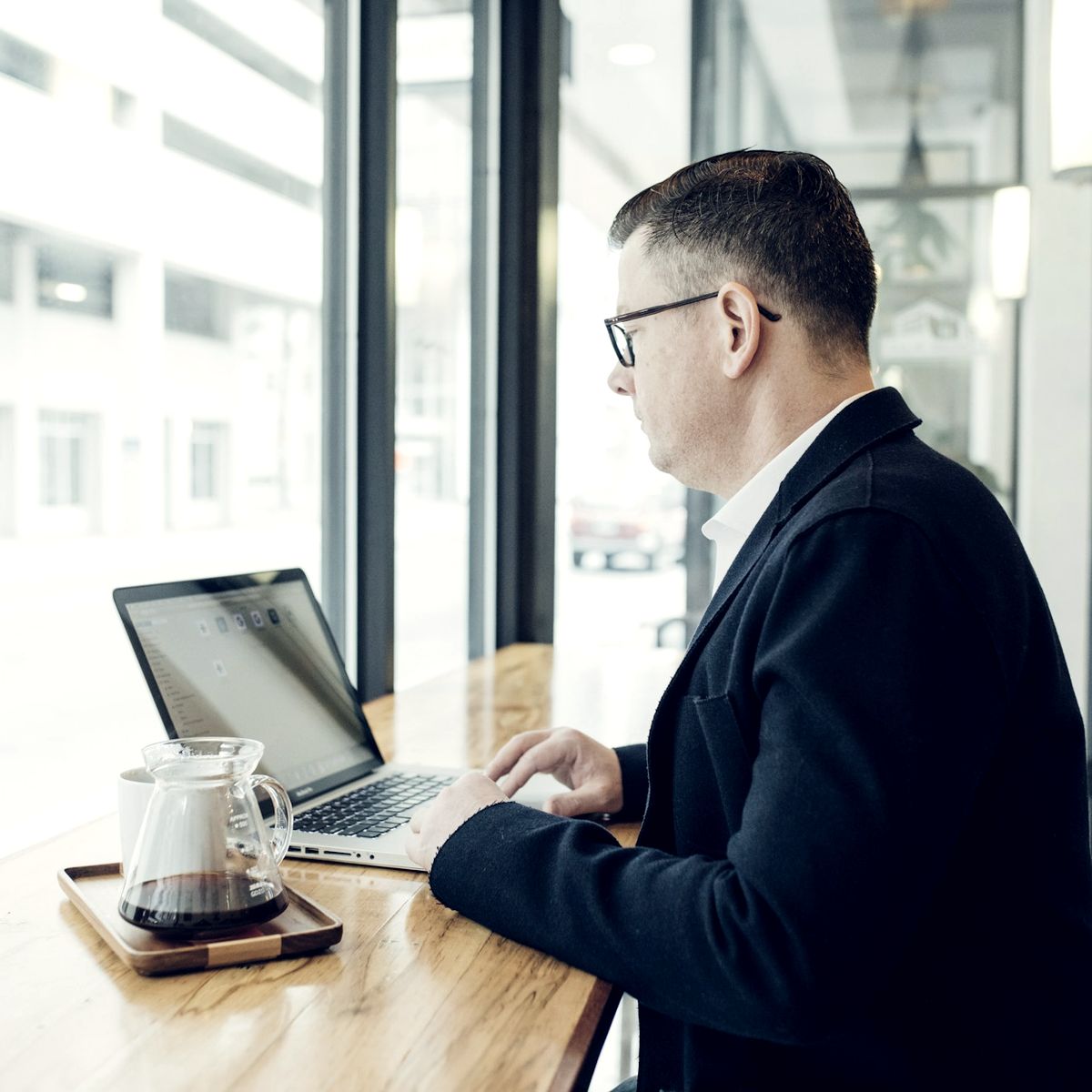 Attorney working on a laptop at a bright office window